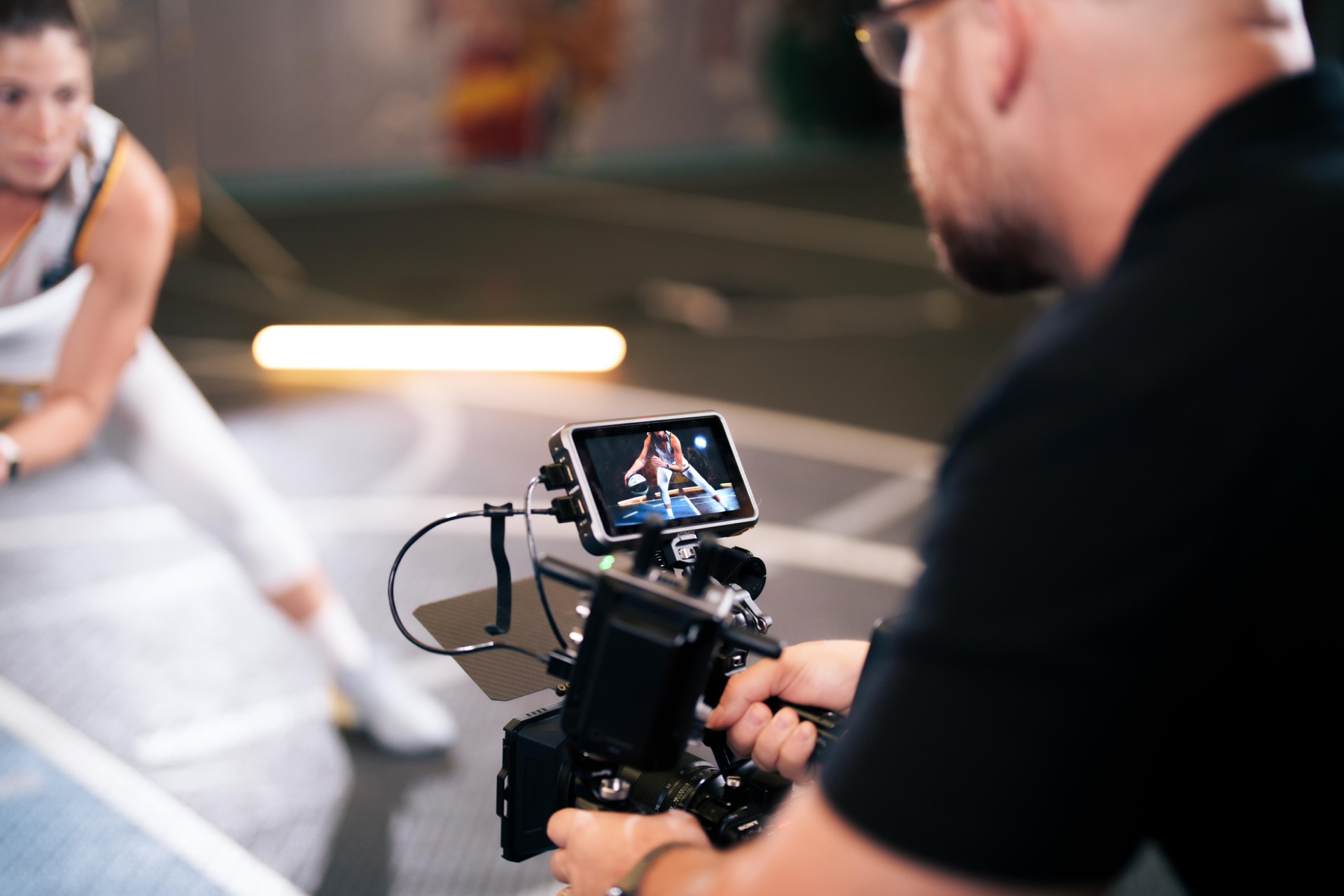 Camera operator filming a basketball player at a media day